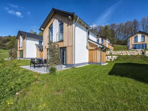 A modern two-story house with a large patio, stone steps, and a wooden fence. - Beautiful apartment in villa for 4 guests with WIFI, TV, terrace and pets allowed (Truppach)