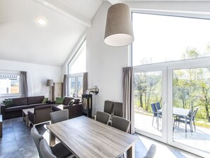 Un vaste espace de vie comprenant une grande table et des chaises, un canapé et une cheminée.