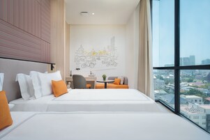 Habitación de hotel moderna con una cama grande, un escritorio y vistas a la ciudad.