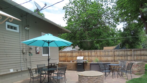 A patio with stone flooring, a barbecue grill, and outdoor furniture.