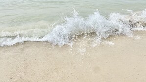 A beach with waves crashing onto the shore. - Beach Front, Balcony access from den and master, Spacious living, fully equipped (Gulf Shores)