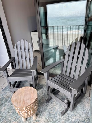 Relax in style with ocean views from the balcony, featuring Adirondack chairs and a serene seascape.