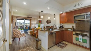 Una cucina moderna con mobili in legno, elettrodomestici in acciaio inossidabile e vista all'esterno.