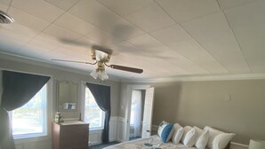 A bedroom with a large bed, a dresser, a vanity, and a ceiling fan. - Sandusky 4 BR, 2-bath home. 3.5 Mi from Cedar Point. 3.2 Mi to Sports Force. (Sandusky)