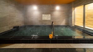 A hot tub area with a wooden ceiling, tiled walls, and a sign with text. - SuperHotel Yahaba-Eki Higashiguchi (Yahaba)