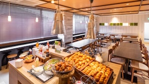 A buffet setup with various food items, including pastries and condiments, in a well-lit dining area with wooden furniture and large windows. - SuperHotel Yahaba-Eki Higashiguchi (Yahaba)