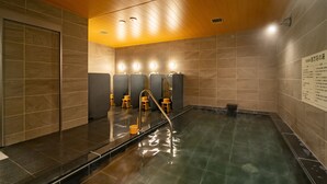 A modern indoor swimming pool with a clear water surface, a central diving board, and multiple changing cubicles with mirrors. - SuperHotel Yahaba-Eki Higashiguchi (Yahaba)