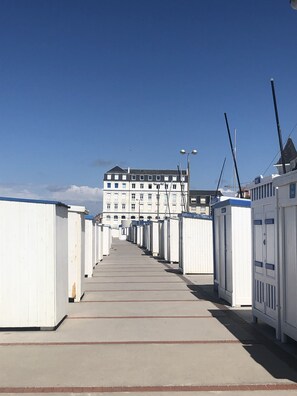 A row of white portable cabins with a building in the background.