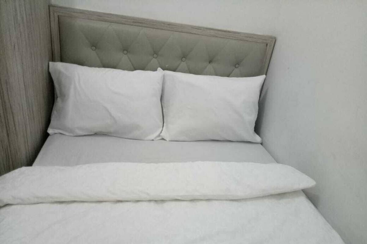 A bed with a tufted headboard and two pillows.