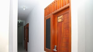 A hallway with a wooden door labeled "101" and a window. - Hotel Syariah Mama Kutajaya Pasar Kemis (PasarKemis)