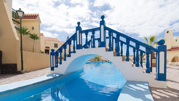 Une piscine avec un pont bleu et blanc.