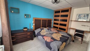 A bedroom with a bed, a dresser, a nightstand, a wall-mounted shelf, and a ceiling fan. - "Le Rouge" T2 Climatisé Près Centre Ville Avec Terrasse Extérieure/parking/wifi (Avignon)