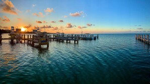 A pier extending into calm waters with a sunset in the background. - Anglers Reef Islamorada  home with ocean views, private marina, beach & pool (Islamorada)