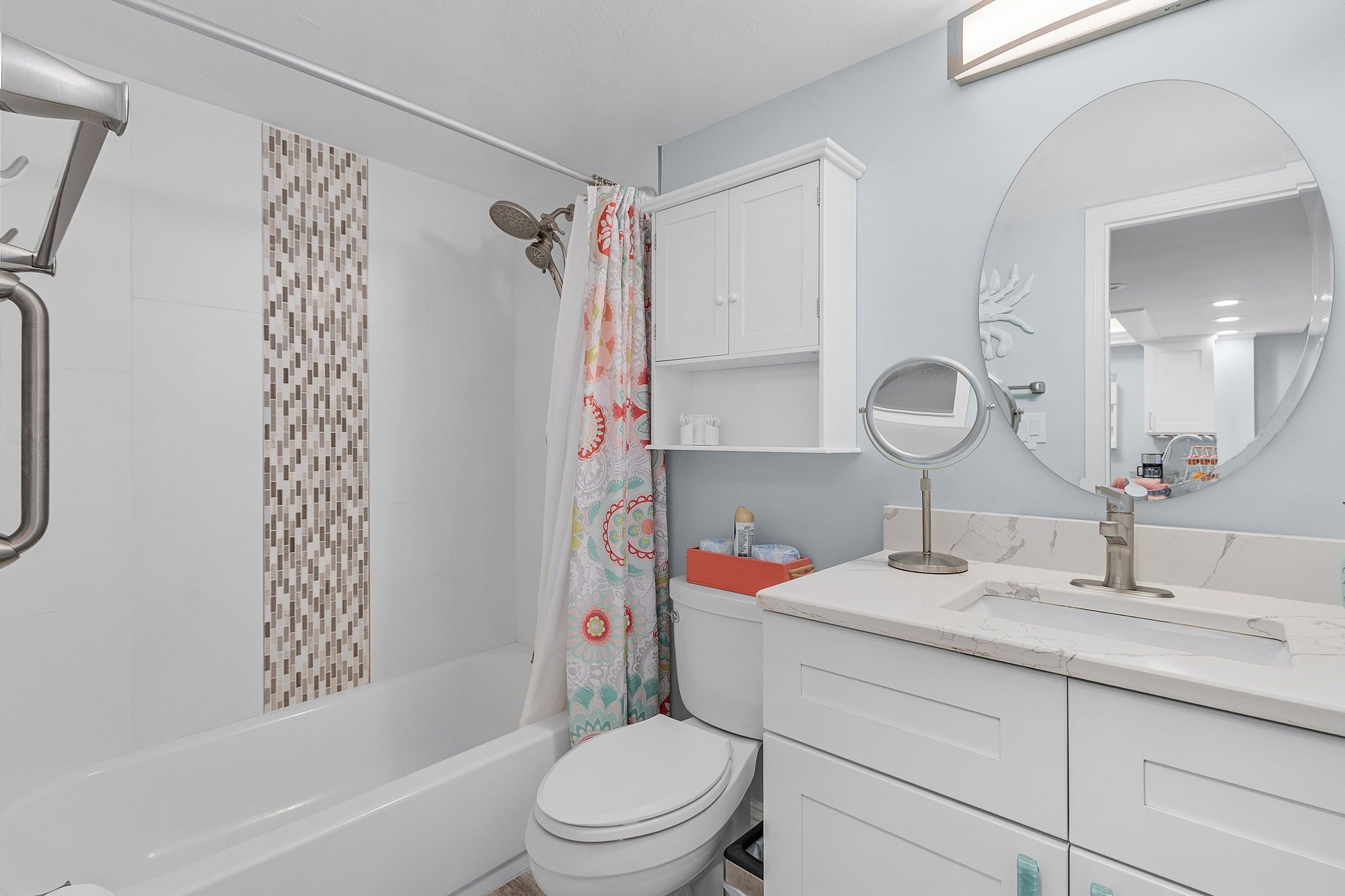 Une salle de bain avec douche, toilettes et lavabo.