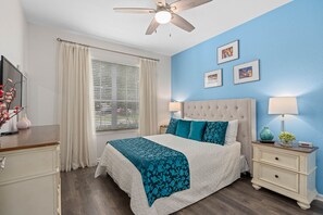 A bedroom with a bed, nightstands, a ceiling fan, and a window with curtains. - FROZEN,HARRY POTTER,MICKEY THEMED ROOMS,ENCANTO GAME ROOM 
5 MINUTES FROM DISNEY (Kissimmee)