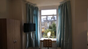 A room with a desk, chair, and a TV mounted on the wall. - Stafford House (Sheffield)