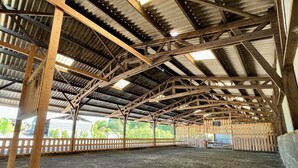 Una gran estructura abierta, similar a un granero, con techo alto y vigas de metal.