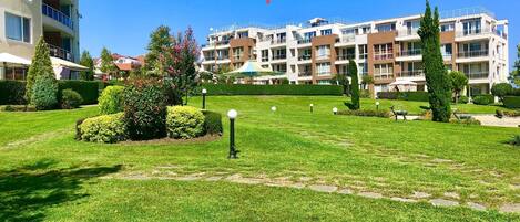 A sea view apartment complex named Zenith with well-maintained lawns and a clear sky.