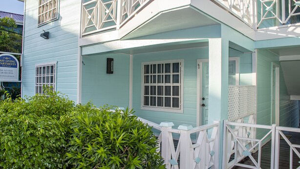 A light blue building with white railings and a porch.