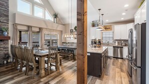 A spacious kitchen with wooden flooring, a central island, and stainless steel appliances.