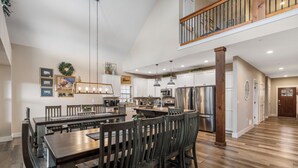 A spacious kitchen with a large island, wooden chairs, and a dining table.