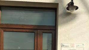 A wooden door with a glass panel, a compass rose, and a wall-mounted sign with booking information. - B&B Vecchia Darsena - Your home on the old port - Room "the rudder" (Augusta)