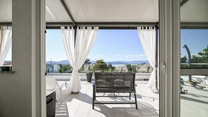 A balcony with a chair, white curtains, and a view of the sea and mountains. - Stunning home in Malinska with heated swimming pool (Malinska)