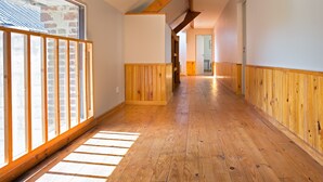 A hallway with wooden flooring, wooden paneling on the walls, and a large window on the left. - CHARMING ALL COMFORT gîte near the Baie de Somme (Aigneville)