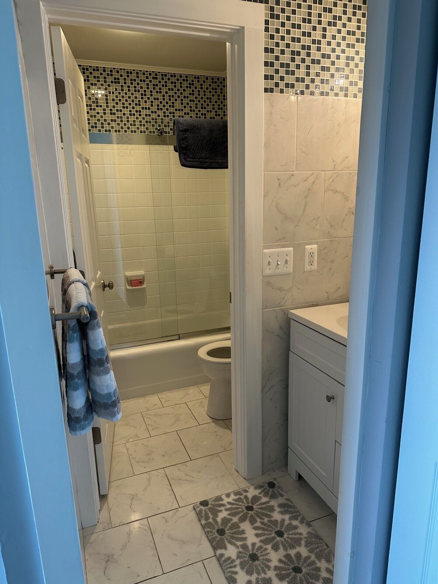 A bathroom with a shower, toilet, and sink.