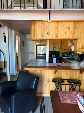 Una cocina moderna con armarios de madera, horno empotrado y microondas.