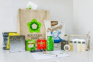 A variety of grocery items, including organic chips, Twinings tea, and body wash, arranged on a countertop. - Axel Apartments 103 The Hadley (Glen Iris)
