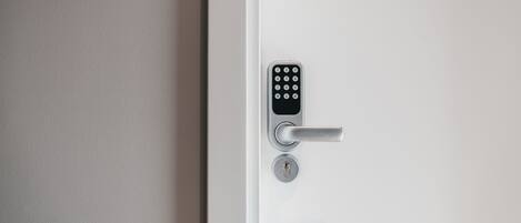 A modern door with a keypad lock and a keyhole.