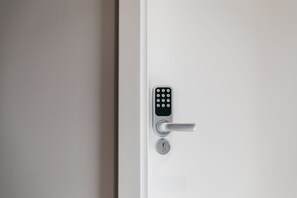 A modern door with a keypad lock and a keyhole. - &Tales Suites - Óbidos (Obidos)