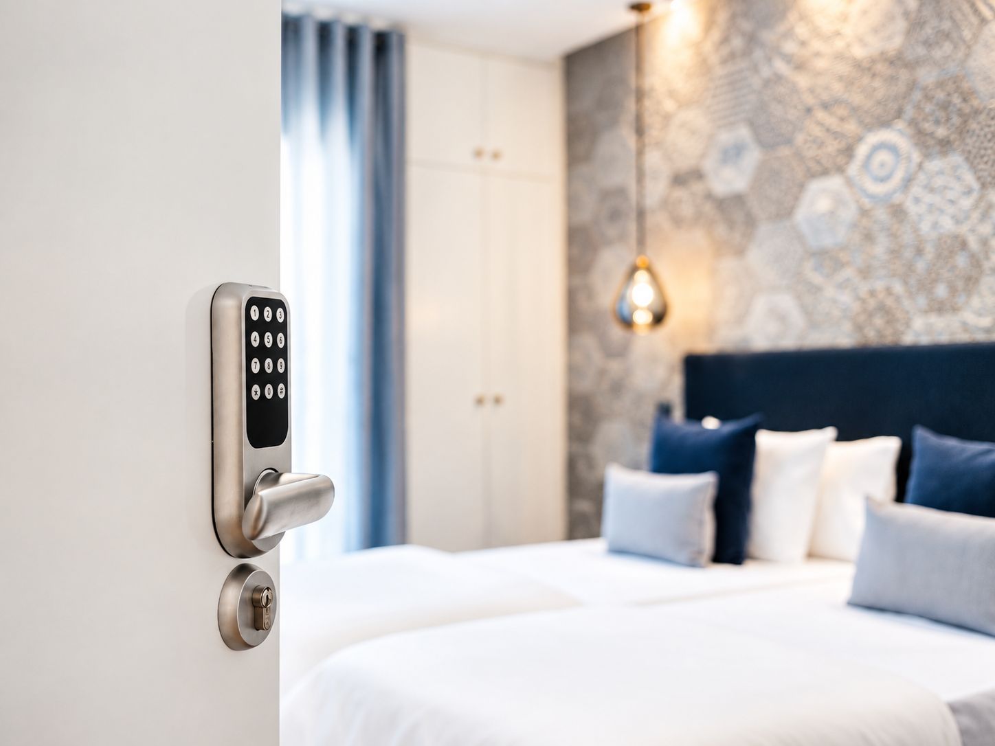 A hotel room with a modern bed, a wall-mounted control panel, and a patterned wall.