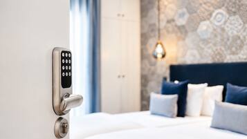 A hotel room with a modern bed, a wall-mounted control panel, and a patterned wall.