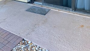 Een balkon met een schuifdeur die leidt naar een slaapkamer met een bed en uitzicht op het strand.