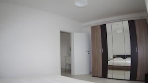A bedroom with a bed, a wardrobe, and a door leading to another room. - Apartment in Krnica Near Beach & BBQ (Marcana)