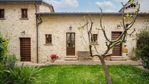 A stone building with a courtyard, featuring a small tree, a bench, and a flower pot. - Farmhouse in Citta di Castello With Pool (Città di Castello)