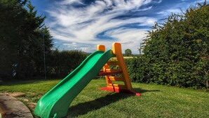 A playground with a green slide and orange climbing structure. - Attractive Mansion With Pool (Cortona)