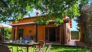 An outdoor dining area with a table set for two, surrounded by wicker chairs. - Attractive Mansion With Pool (Cortona)