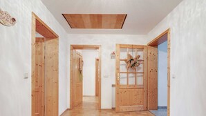 A hallway with wooden doors, a skylight, and a wooden floor. - Apartment With all Amenities, Garden and Sauna (Schoensee)