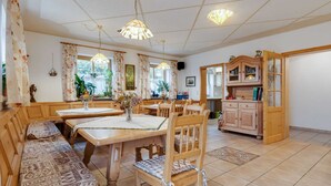 A spacious dining area with a long wooden bench and a table, surrounded by chairs. - Apartment With all Amenities, Garden and Sauna (Schoensee)