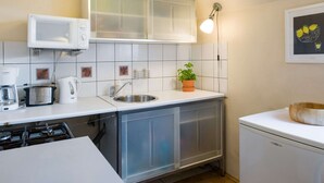 A compact kitchen with a microwave, toaster, kettle, sink, and a small refrigerator. - Apartment Krakow Near Wawel Castle (Kraków)
