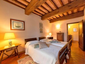 Cozy bedroom with a double bed, bedside tables, and sloped ceiling with exposed beams.