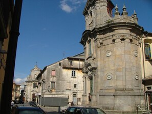 A historic building with a prominent tower and a sign that reads "non solo abbigliamento".
