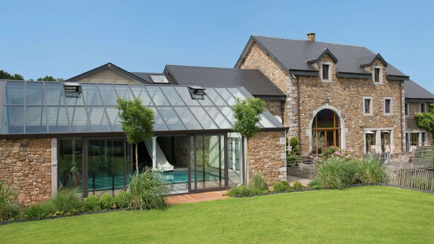 A modern house with a glass conservatory, stone exterior, and a well-maintained lawn. - Luxury Spa Retreat in Theux (Theux)