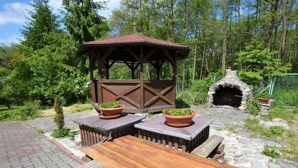 A rustic outdoor seating area with wooden benches and a covered gazebo, surrounded by greenery and a stone oven. - Idyllic Villa With Private Pool in Trebusin Czech Republic (Trebusin)