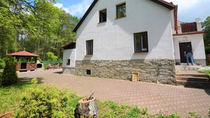 A two-story building with a stone base and a white upper section, a small porch, and a wooden structure to the left. - Idyllic Villa With Private Pool in Trebusin Czech Republic (Trebusin)