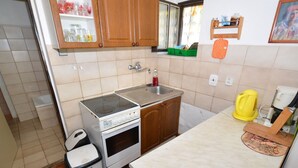 A compact kitchen with a stove, sink, and a trash bin. - Idyllic Villa With Private Pool in Trebusin Czech Republic (Trebusin)