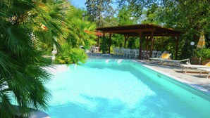 A swimming pool with lounge chairs and a gazebo. - Belvilla by OYO Casa Rosa (Terranuova Bracciolini)